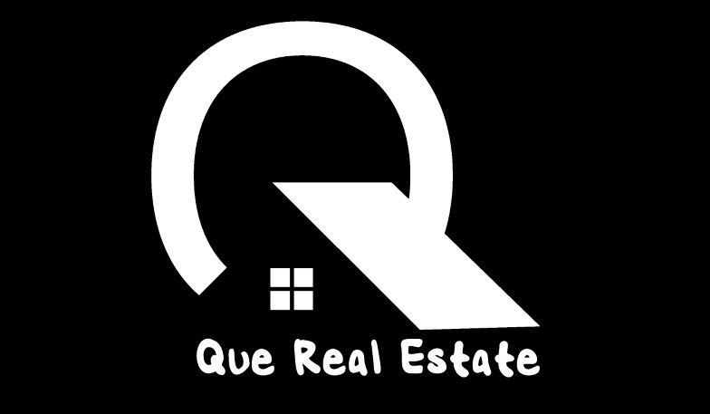 A logo development in white with symbols and text stating Que Real Estate